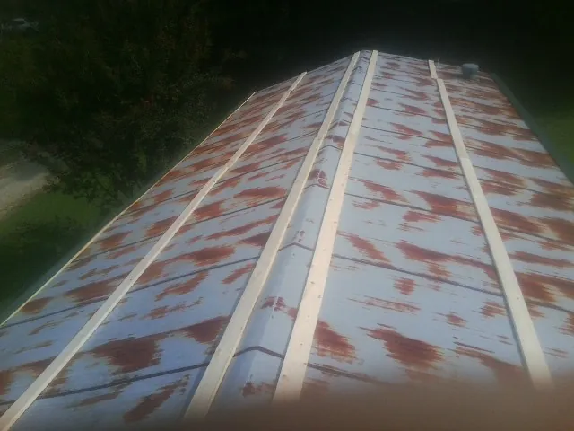 Rusted metal roof panels with new wood purlins before replacement — Storm Damage Roof Repair in Millington by Roofing Brothers
