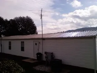 New metal roof on a single wide mobile home with a TV antenna in Millington